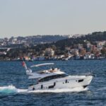Reviews Luxury yacht cruising along the Bosphorus with Istanbul's skyline in the background on a sunny day.
